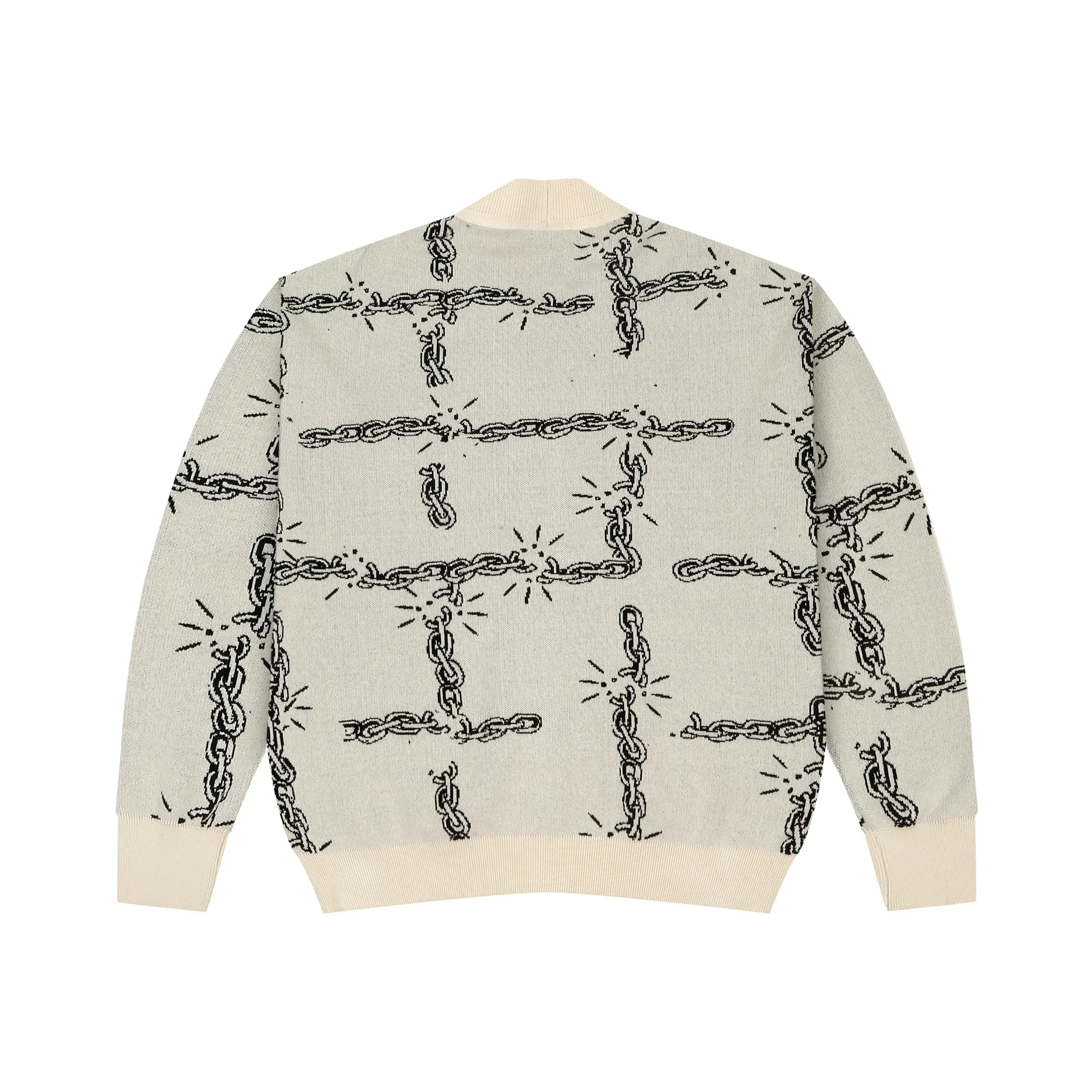 Cream knit sweater with black broken chain pattern and ribbed cuffs and hem