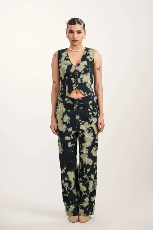 Woman wearing black and beige tie-dye buttoned vest and matching wide-leg pants in studio