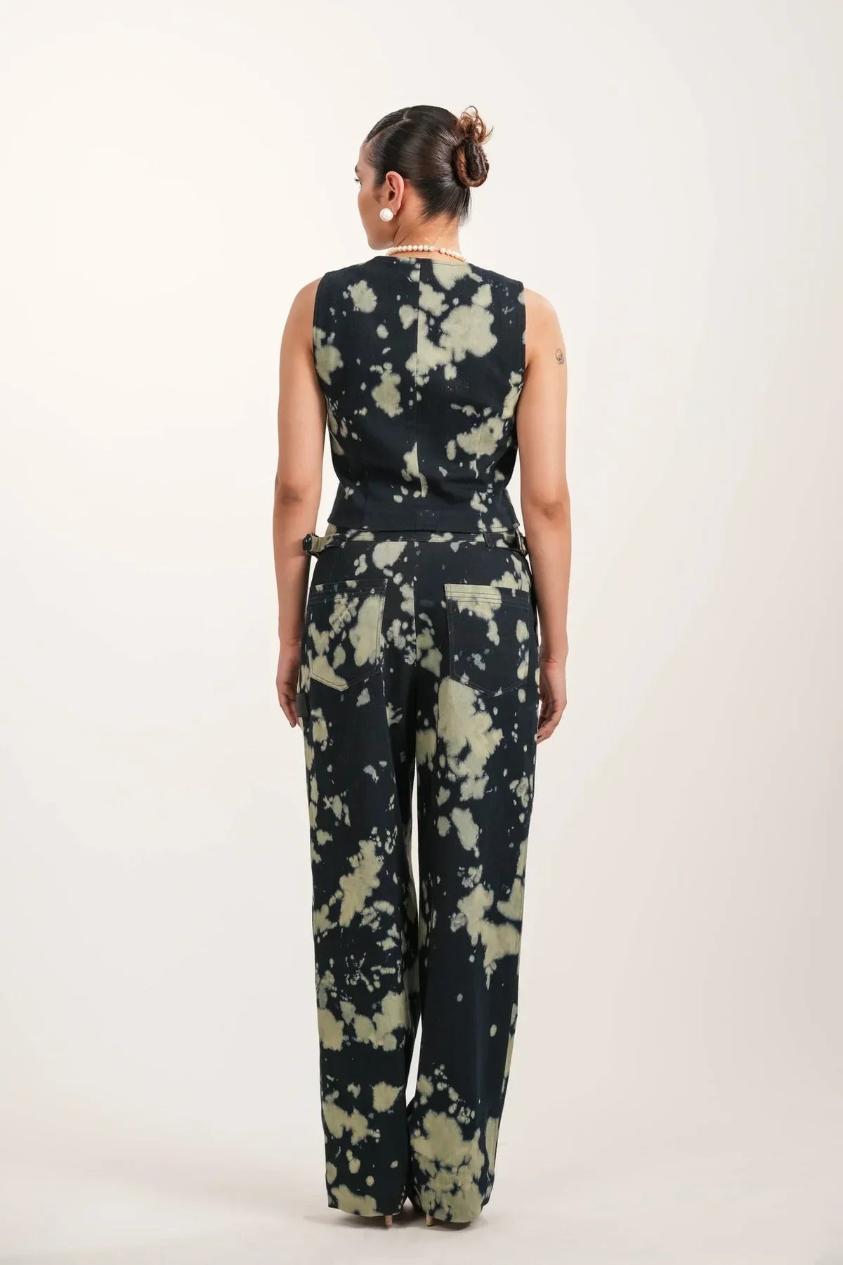 Woman wearing black tie-dye sleeveless top and matching wide-leg pants from rear