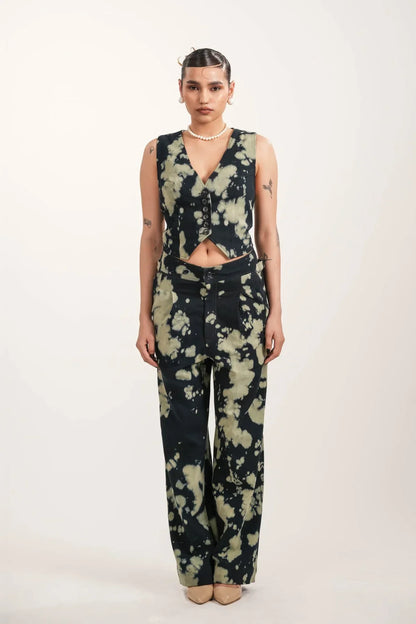 Woman wearing black and beige tie-dye buttoned vest and matching wide-leg pants in studio