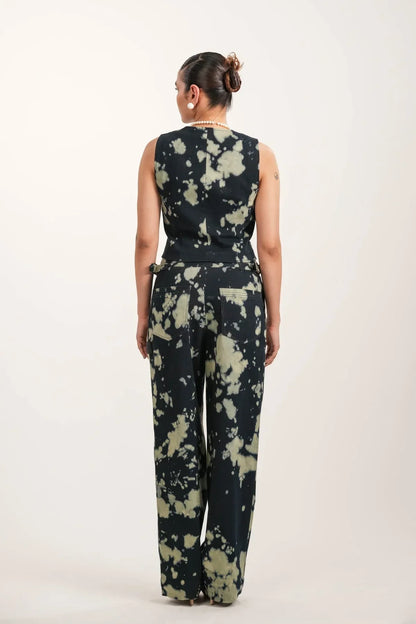 Woman wearing black tie-dye sleeveless top and matching wide-leg pants from rear